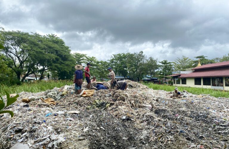 Waste collectors sift through trash in Ward 11. Rachel Moon. July 2023