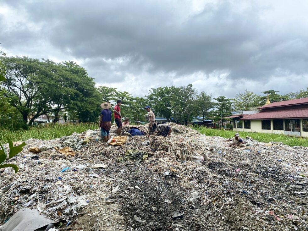 Waste collectors sift through trash in Ward 11. Rachel Moon. July 2023